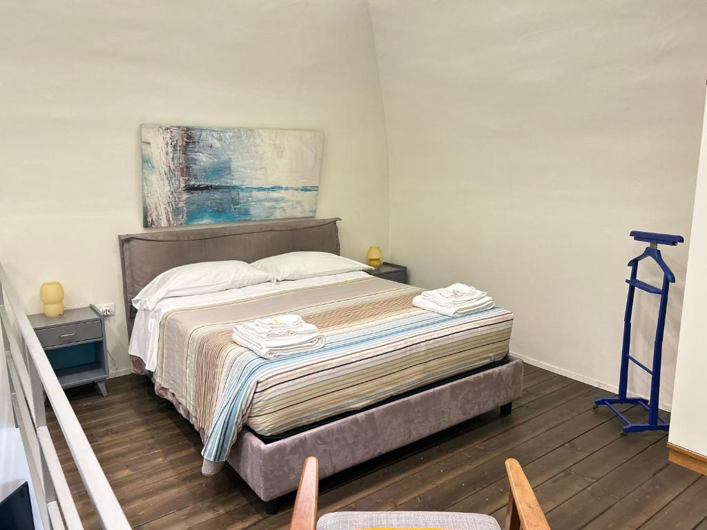 a bedroom with a bed with a painting on the wall at SanBiagio, 25 Guesthouse in Naples