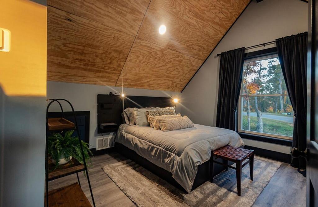 une chambre avec un grand lit et une fenêtre dans l'établissement Charlis Place Private Lux Cabin HotTub MT Views, à Ellijay