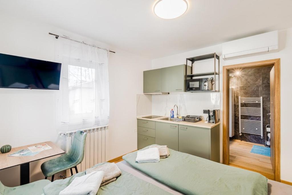 a kitchen with a bed and a table and a desk at Penzion Hosnar, apartma Mucho in Bovec