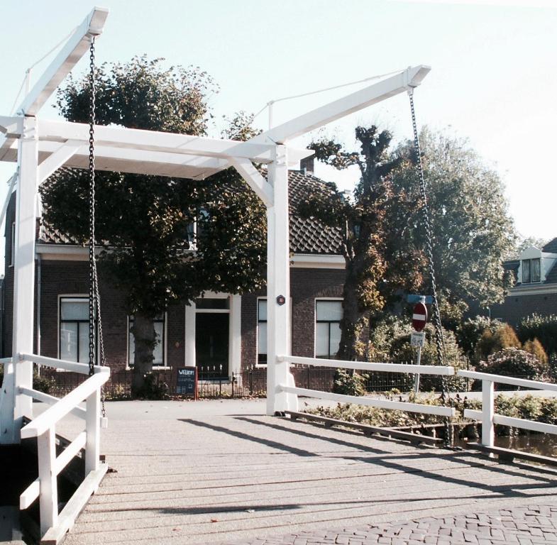 una pérgola blanca delante de una casa en House of Cocagne en Kockengen