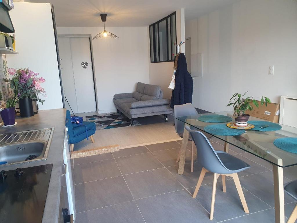 a kitchen and living room with a table and a couch at La belle escale landaise - PDJ inclus, parking, gare & proche Hossegor in Saint-Vincent-de-Tyrosse