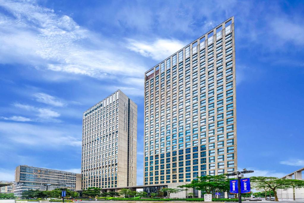 two tall buildings in a city with a cloudy sky at eStay Residence·Poly World Trade Center Guangzhou in Guangzhou