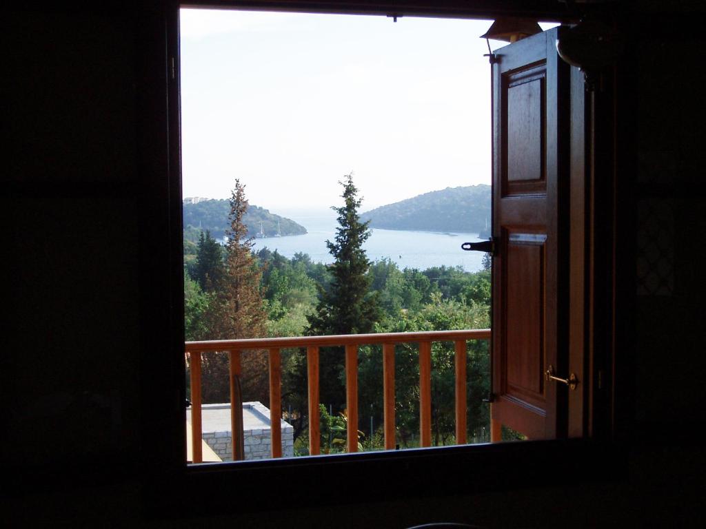 a room with a window looking out at a lake at Alkyon Villas in Syvota