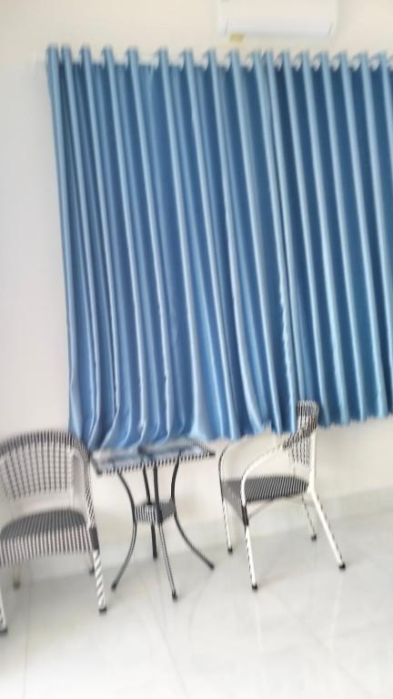 3 sedie sedute davanti a una tenda blu di HCt a Phu Quoc