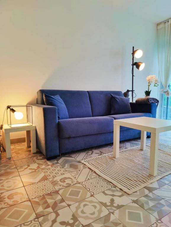 un salon avec un canapé bleu et une table dans l'établissement Carré d'Or - Studio lumineux à 5 minutes de la plage, à Nice