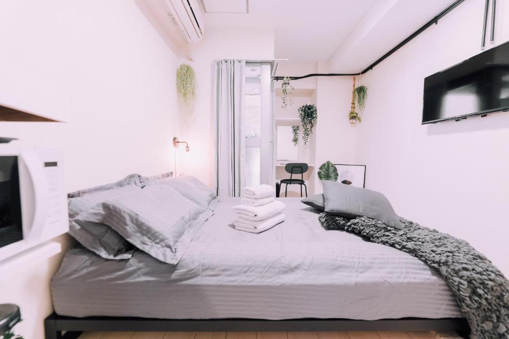Un dormitorio blanco con una cama blanca y una ventana. en Minimalist Loft 8 Namba Compact Studio and Gym MA802, en Osaka