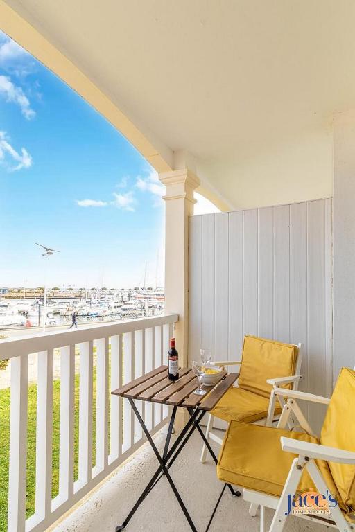 un patio avec deux chaises et une table sur un balcon dans l'établissement Grand T2 en 1ère ligne Vue mer sur le Petit Port, à Arcachon