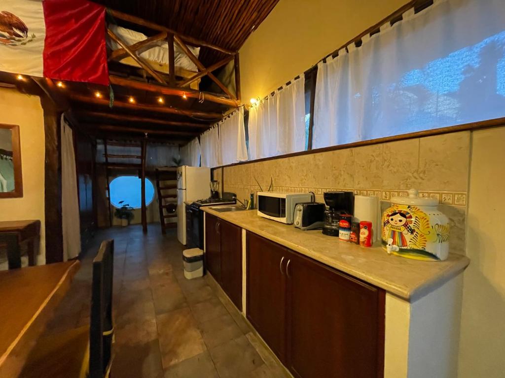 a kitchen with a counter top with a microwave at Treehouse Loft in Prime Location in Playa del Carmen