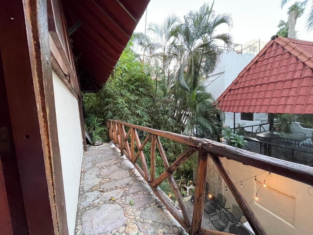 a balcony with a wooden railing and palm trees at Treehouse Loft in Prime Location in Playa del Carmen