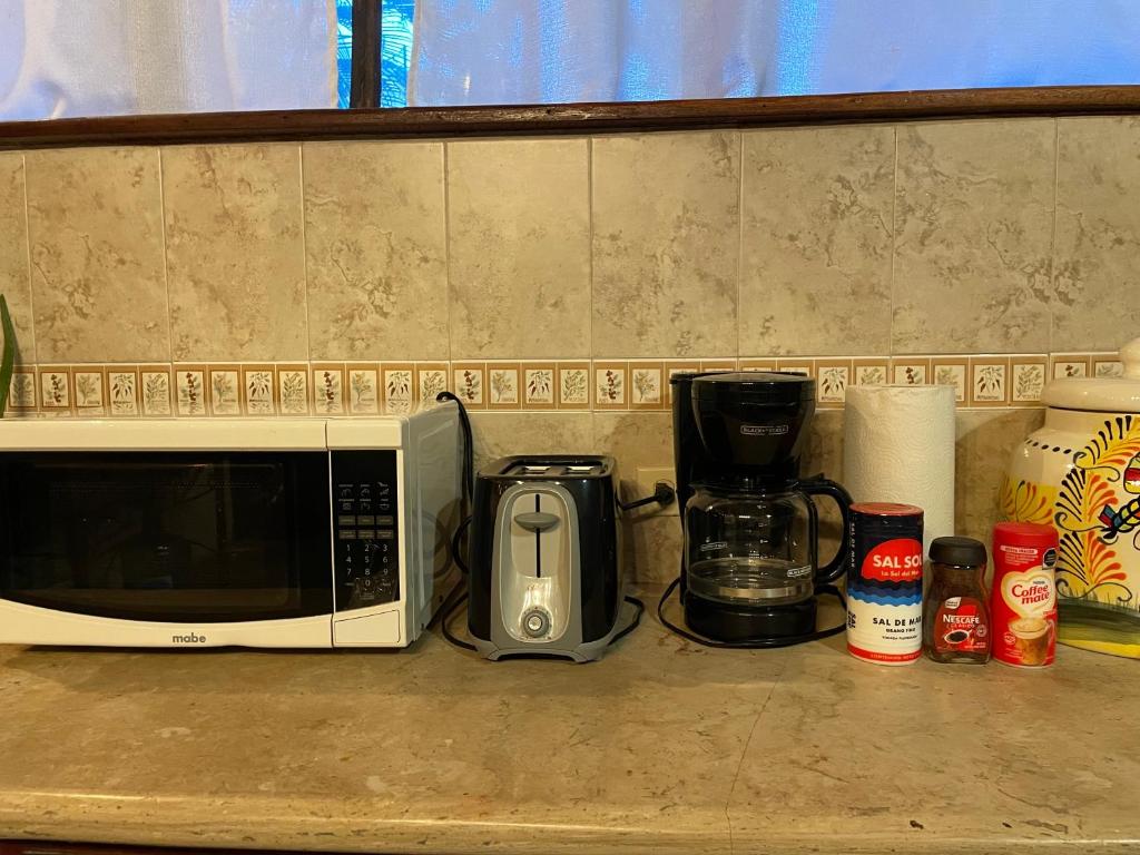 a kitchen counter with a microwave and a coffee maker at Treehouse Loft in Prime Location in Playa del Carmen