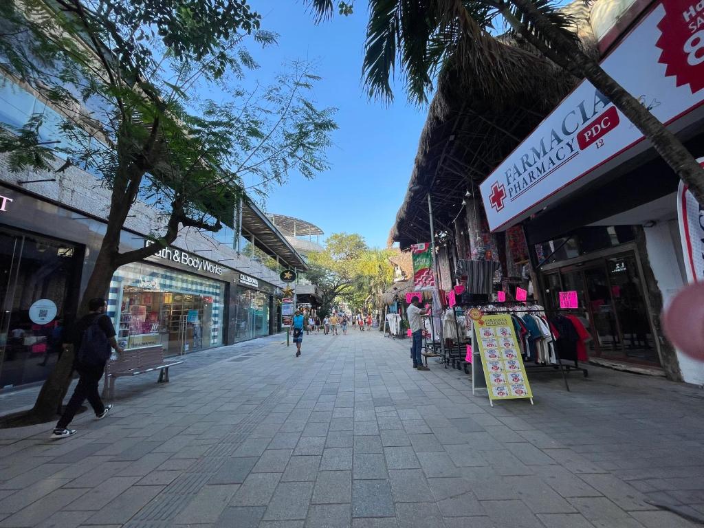a street with shops and people walking down the street at Treehouse Loft in Prime Location in Playa del Carmen
