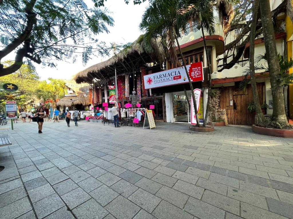 a street in a city with people walking down the street at Treehouse Loft in Prime Location in Playa del Carmen