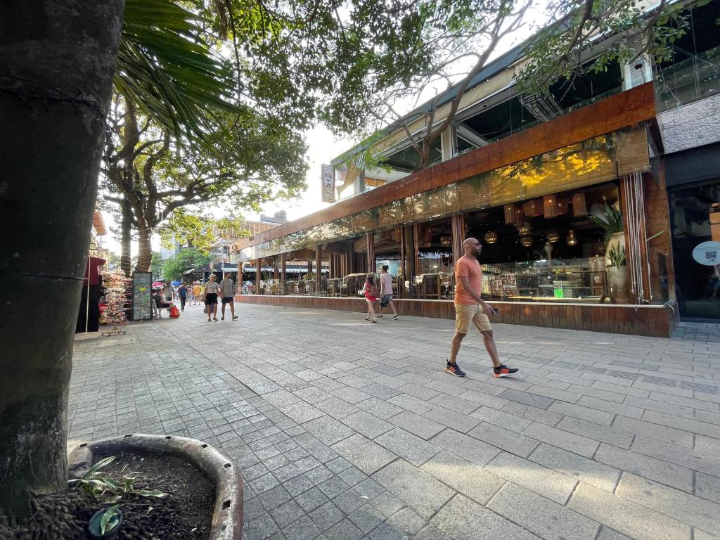 a man walking down a street in front of a store at Treehouse Loft in Prime Location in Playa del Carmen