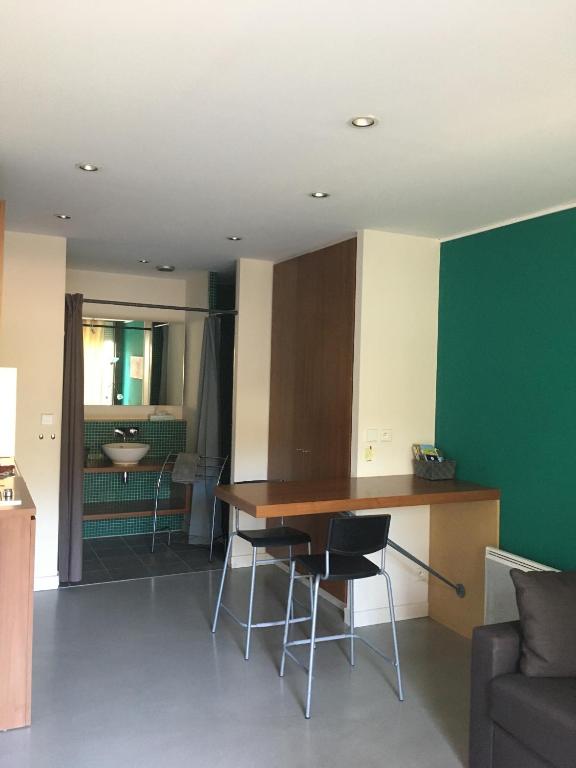 une cuisine et un salon avec une table et des chaises dans l'établissement Studios Colorés Pont Roman, à Nyons