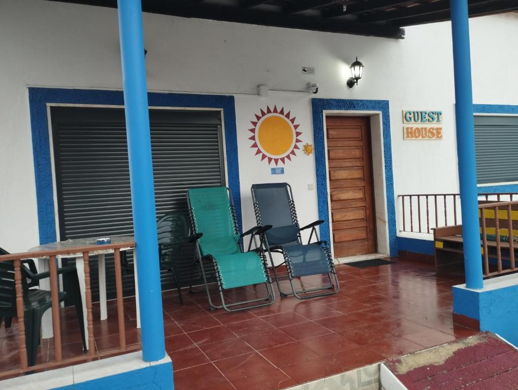a room with chairs and a table and a building at Monte Sol Nascente in Grândola