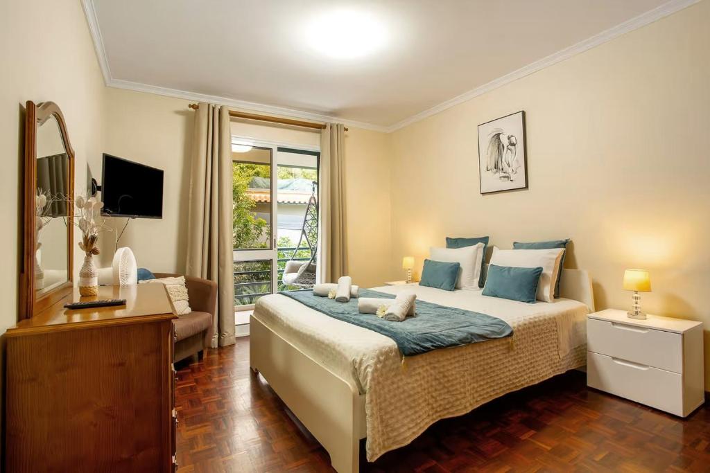 a bedroom with a large bed and a couch at Madeira Funchal Gardens in Funchal