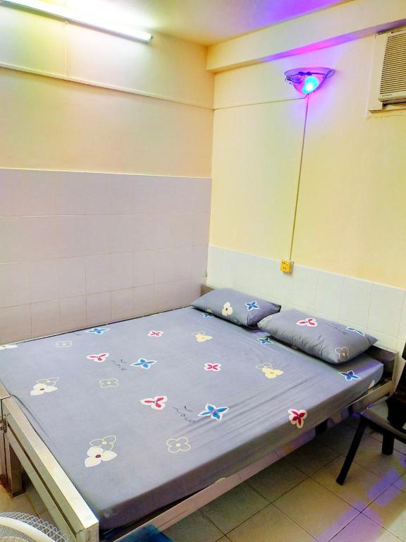 a bed in a room with a blue comforter on it at Jade Crown in Yangon