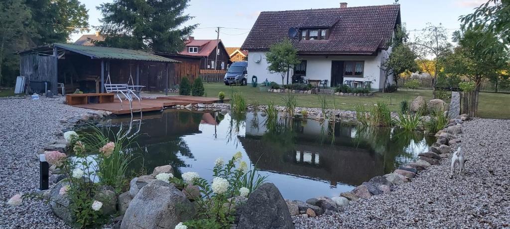 un laghetto nel cortile di una casa di Ferienhaus mit Schwimmteich in idyllischer Lage a Jeleniewo