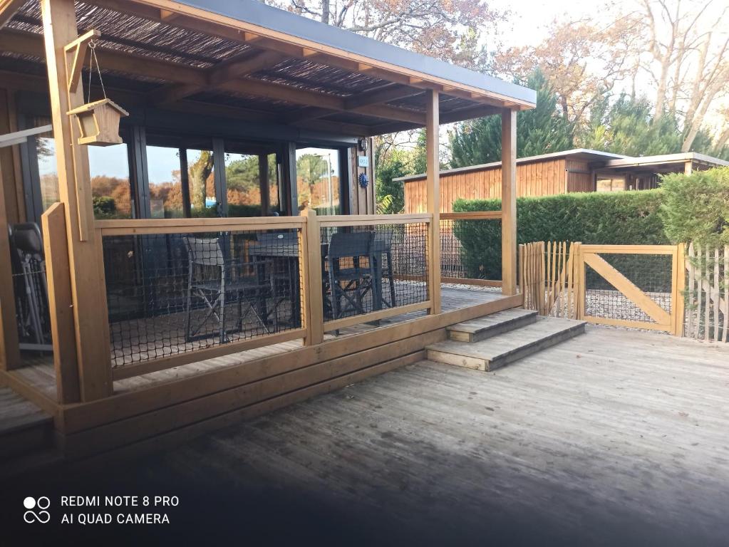 una terraza cubierta con una parrilla y sillas en Chalet RUISSEAU 02, en La Teste-de-Buch
