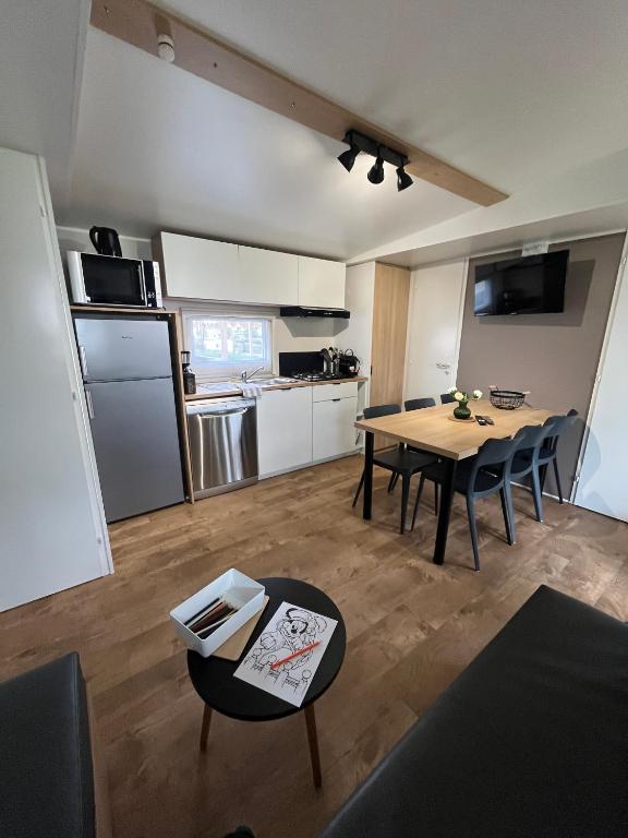 une cuisine et une salle à manger avec une table et des chaises dans l'établissement Confort Mobilhome climatisé dans un camping 5 étoiles, à Houlgate