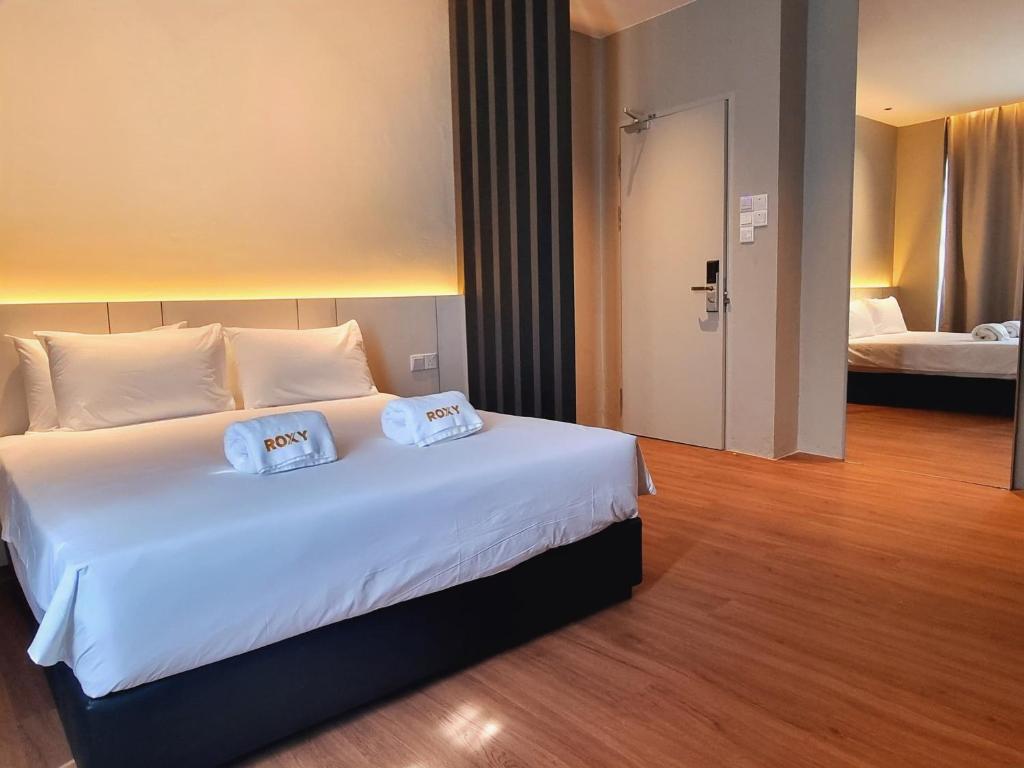 Postel nebo postele na pokoji v ubytování Roxy Hotel Malihah