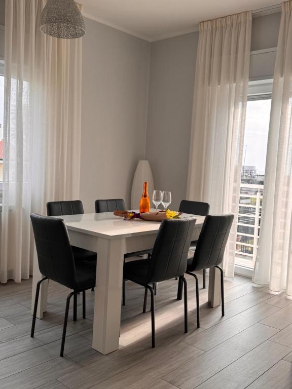 a dining room with a white table and chairs at La Casa Vista Mare in Fregene