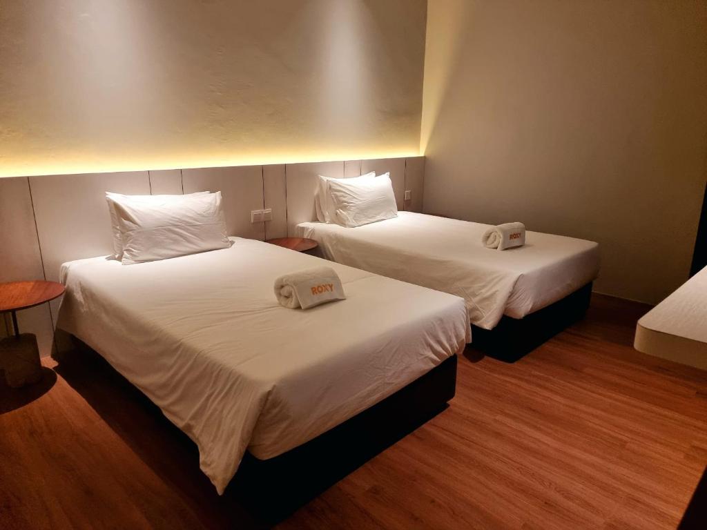 Postel nebo postele na pokoji v ubytování Roxy Hotel Malihah
