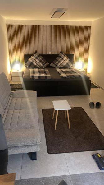 a bedroom with a bed and a couch and a table at Appartment Kuschelecke in Kiefersfelden