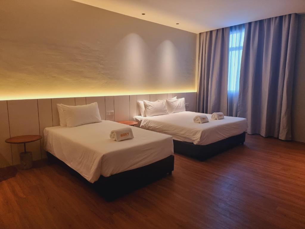 Postel nebo postele na pokoji v ubytování Roxy Hotel Malihah