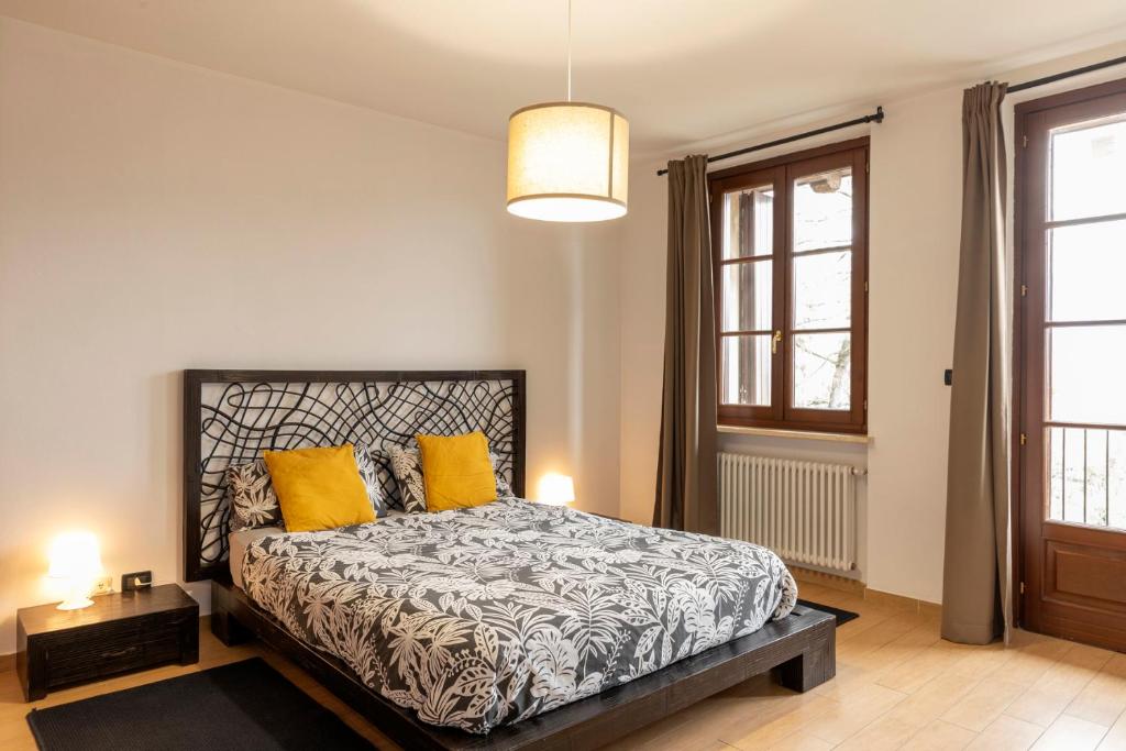 a bedroom with a bed with yellow pillows at Appartamento Palazzo dei Duchi in Avigliana