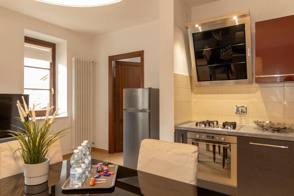 a kitchen with a stainless steel refrigerator and a table at Appartamento Palazzo dei Duchi in Avigliana
