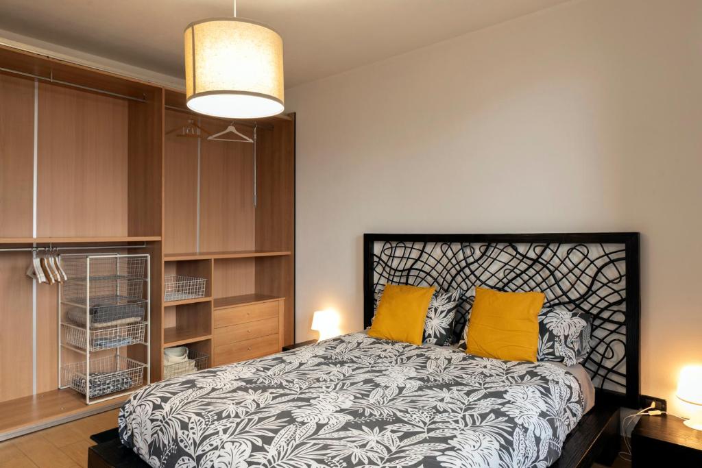 a bedroom with a bed with two yellow pillows at Appartamento Palazzo dei Duchi in Avigliana