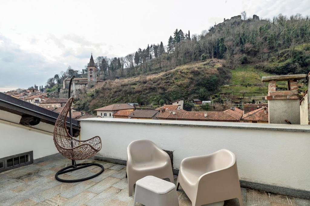 a balcony with two chairs and a bench on a roof at Appartamento Palazzo dei Duchi in Avigliana