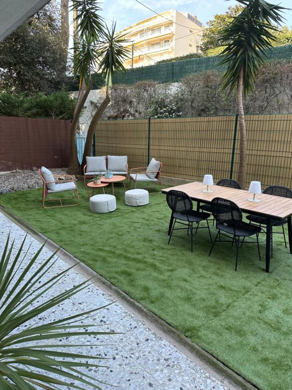 un patio avec une table et des chaises sur l'herbe dans l'établissement T2 with garden and parking, à Cannes