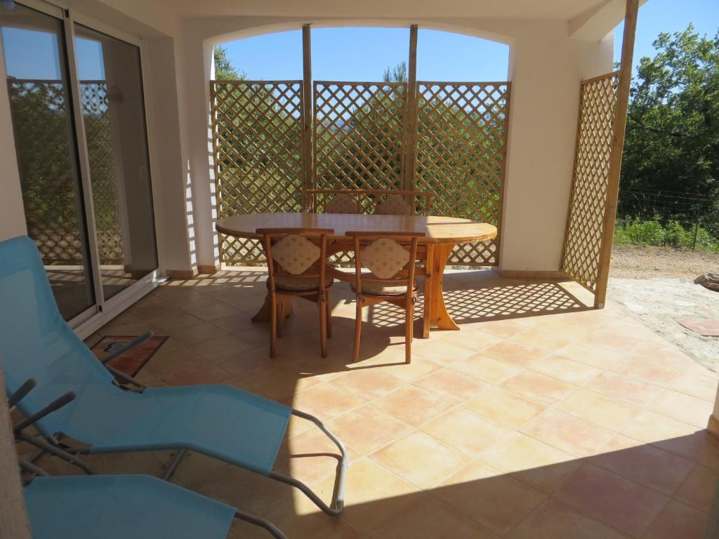 une véranda avec une table et des chaises dans l'établissement Logement au calme au sein de la provence verte, à Seillons-Source-dʼArgens