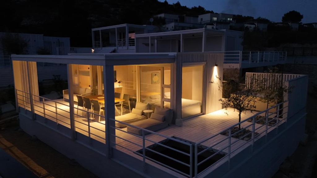 a house with a deck at night at Villa Aria Buqez Vita in Drage