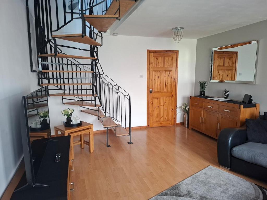 a living room with a spiral staircase in a house at Cosy Manorfield Holiday Home in Kent