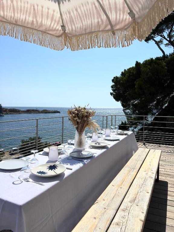 - une grande table avec des plaques blanches et une vue sur l'océan dans l'établissement La Corniche - vue mer à 180 degrés - centre ville, à Bandol