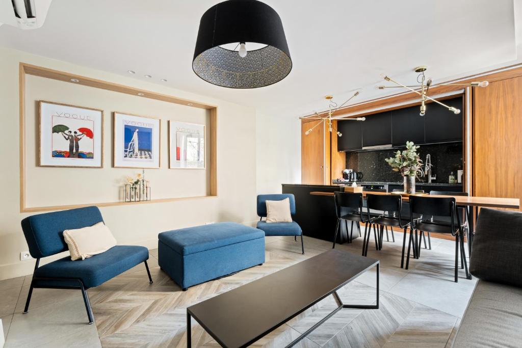 un salon avec une table et une salle à manger dans l'établissement Eiffel Tower - 4 Bedrooms like a Hotel, à Paris