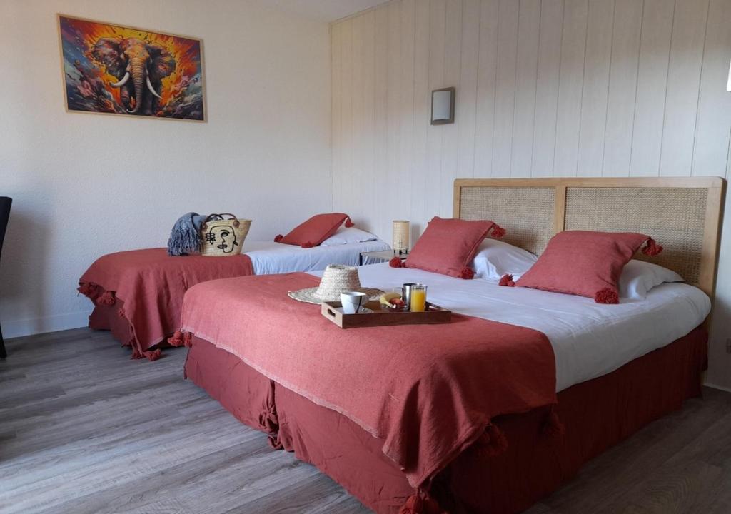 two beds in a room with red and white sheets at Les Jardins de L'Ocean - Climatisé in Biscarrosse-Plage