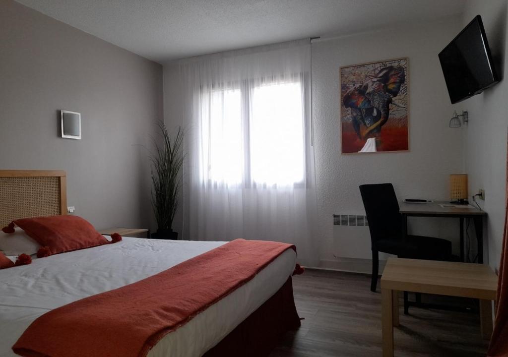 a bedroom with a bed and a desk and a window at Les Jardins de L'Ocean - Climatisé in Biscarrosse-Plage