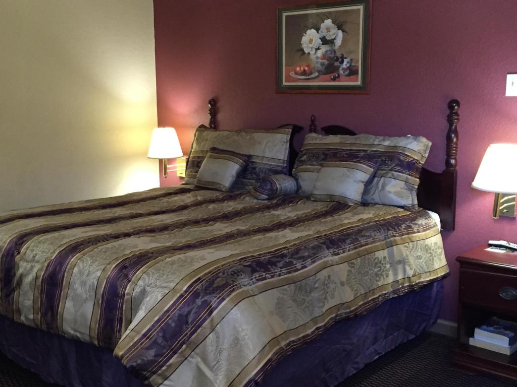 a bedroom with a large bed with two lamps at First Western Inn - Fairmont City in Fairmont City