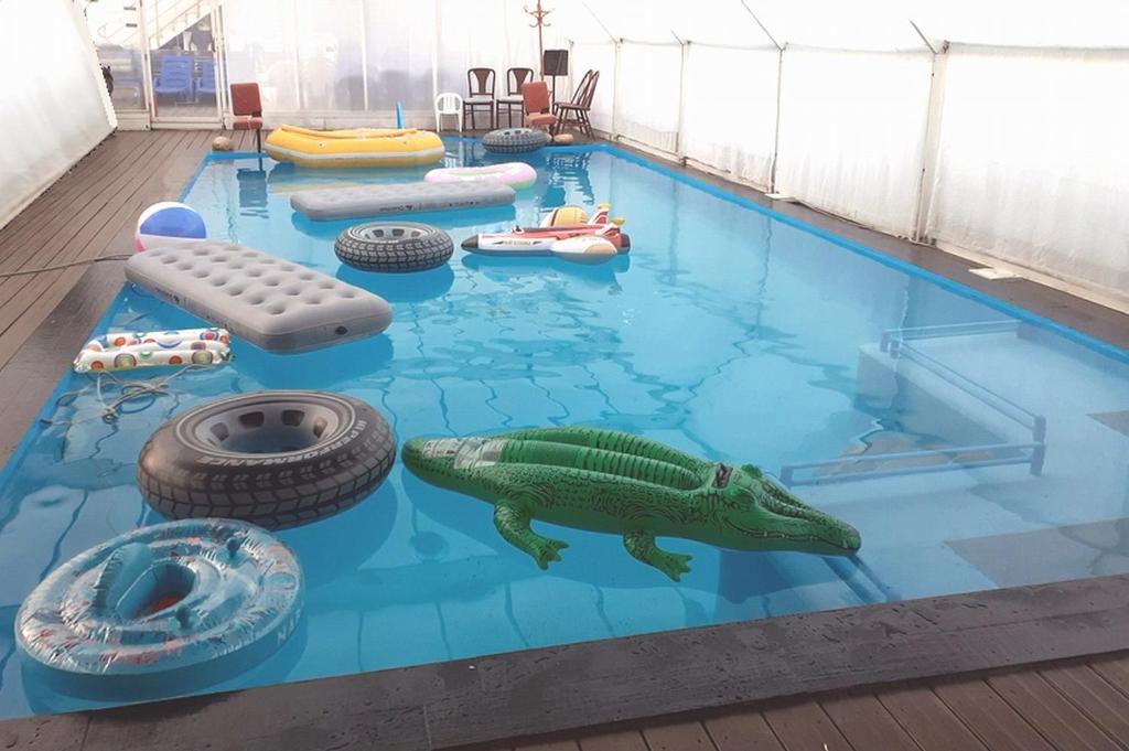 a pool with a toy crocodile in the middle of a exhibit at Villa Les Martinets-Chambres Climatisées-Parking Privé-Piscine-Jacuzzi-Brise Fraîche de la Montagne in Le Poujol-sur-Orb