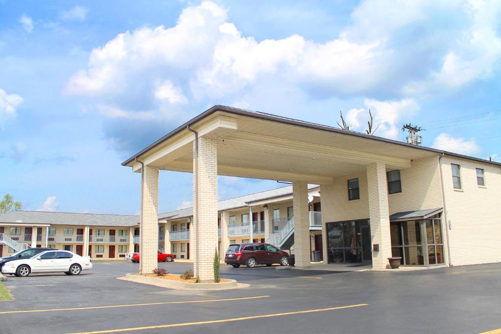 American Inn - Paducah في بادوكا: مبنى كبير وامامه موقف سيارات