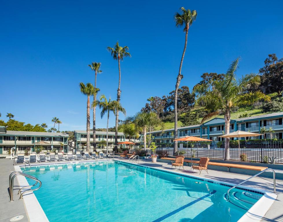 a large swimming pool with chairs and palm trees at The Atwood Hotel San Diego - SeaWorld/Zoo in San Diego