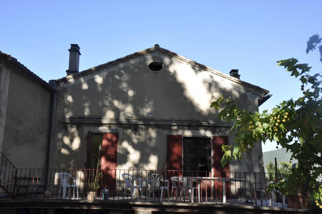 un ancien bâtiment avec des chaises sur un balcon dans l'établissement Grande Maison avec Piscine, juillet et août, Jardin Privatives à NYONS, à Nyons