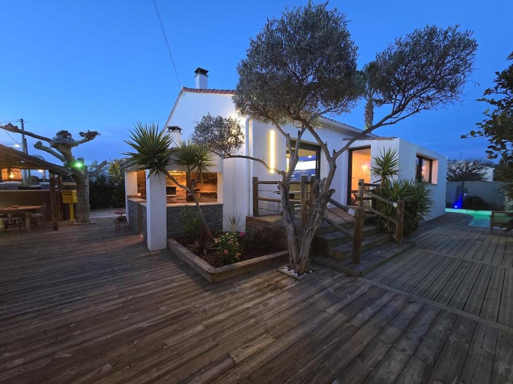 une maison avec une terrasse en bois la nuit dans l'établissement Charming cozy villa, à Saint-Victoret