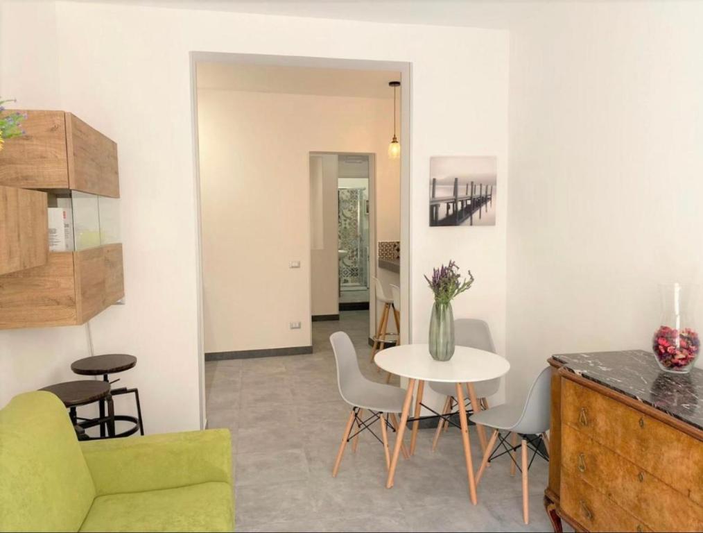 a living room with a table and chairs and a kitchen at SEA & CITY Apartments in Trapani