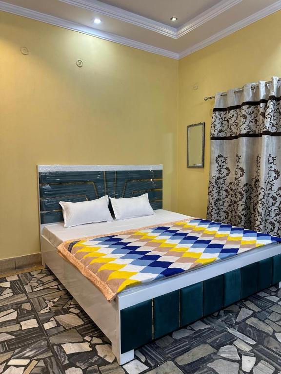 1 cama en una habitación de color azul y amarillo en Dhanani guest house, en Varanasi