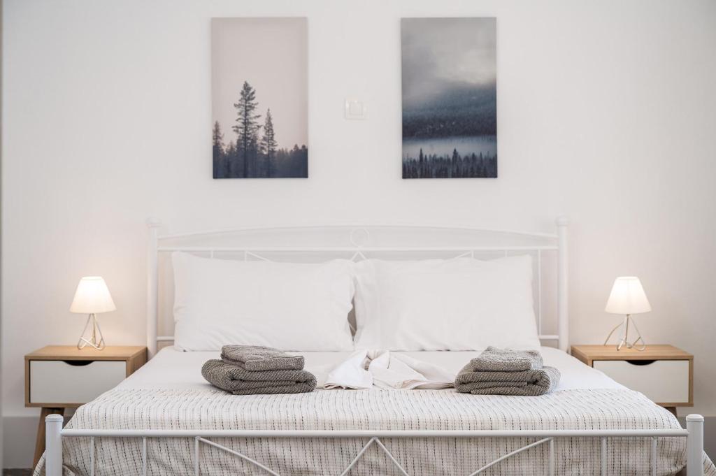 a bedroom with a white bed with towels on it at Ether Seaside Apartment 2 in Pythagoreio
